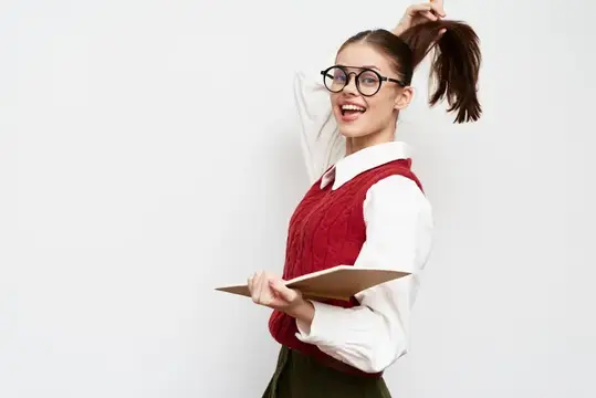 Улыбчивая девушка в очках поправляет хвост с блокнотом в руке