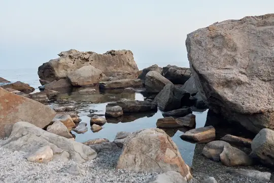 Каменистый берег с валунами и прозрачной водой в пасмурный день