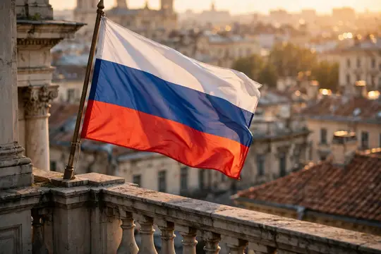 Российский флаг развевается на балконе над вечерним городом