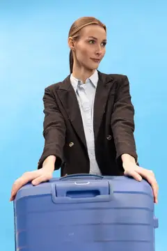 Молодая деловая женщина с синим чемоданом на голубом фоне