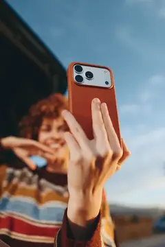 Девушка с рыжими кудрями делает селфи на смартфон