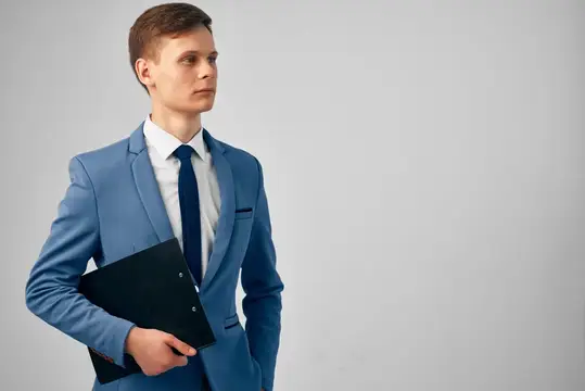 Деловой мужчина в костюме, уверенный в себе, с бумагами в офисе
