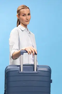 Светловолосая женщина с чемоданом на голубом фоне