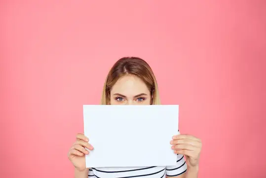 Женщина держит в руках белый лист бумаги