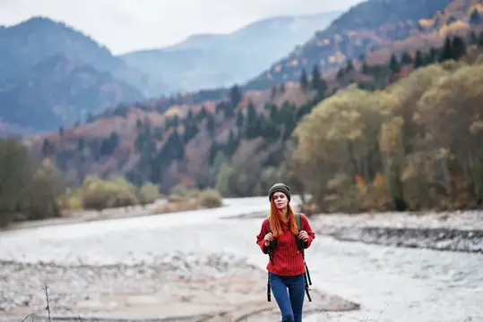 Турист с рюкзаком на берегу реки в горах, утренний пейзаж, модель, туризм
