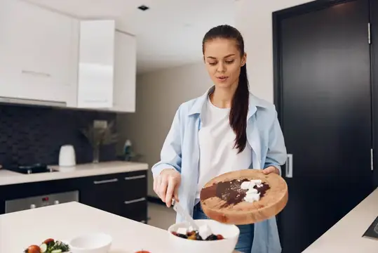 Молодая женщина готовит десерт на кухне