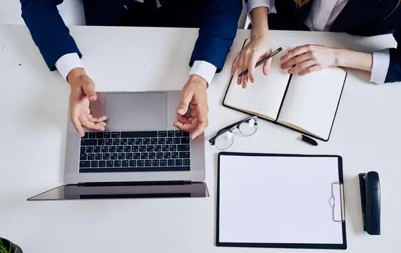 Деловые люди обсуждают проект за ноутбуком в офисе
