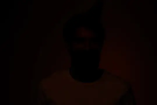 Силуэт мужчины в темноте с едва заметным лицом