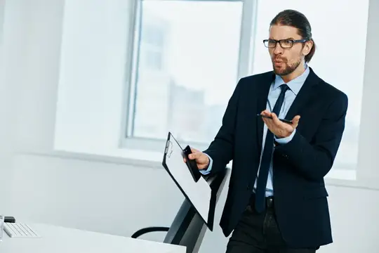 Бизнесмен работает с документами, на его лице читаются эмоции