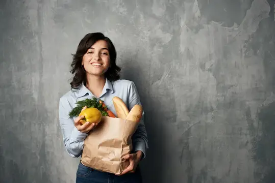 Весёлая брюнетка с сумкой продуктов