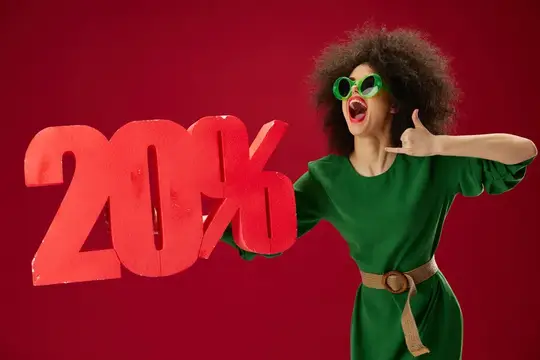 Кудрявая женщина в зелёном платье держит скидку 20%