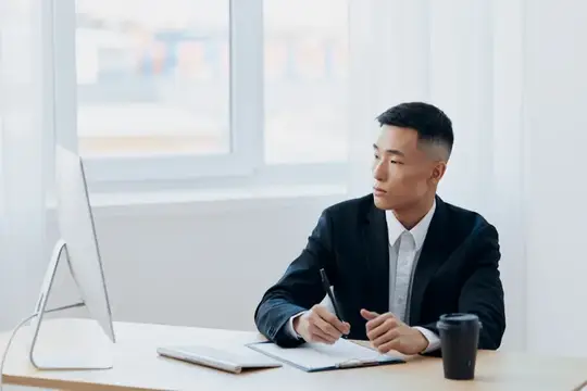 Менеджер работает за компьютером, рядом стакан кофе
