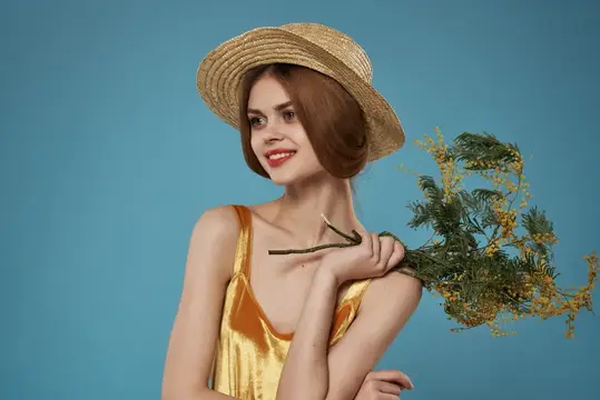Привлекательная женщина в шляпе, украшенной цветами, наслаждается летним отдыхом