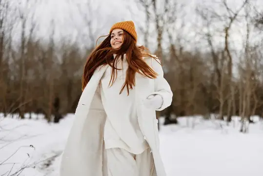 Весёлая женщина гуляет по зимнему полю