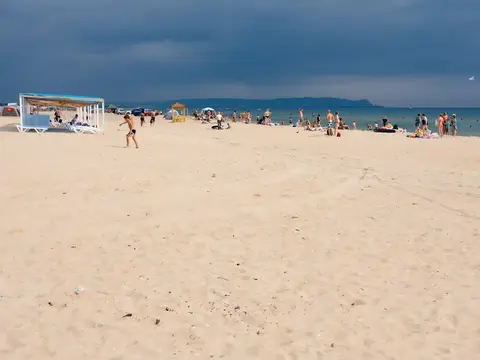 Мальчик бежит по пляжу под надвигающейся грозовой тучей