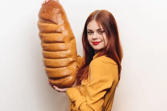 Эмоциональная женщина с большим бутоном на светлом фоне, в жёлтой рубашке и с ярким макияжем
