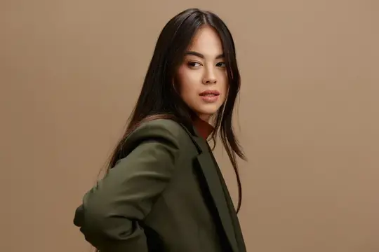 Азиатская девушка с длинными волосами в оливковом пиджаке