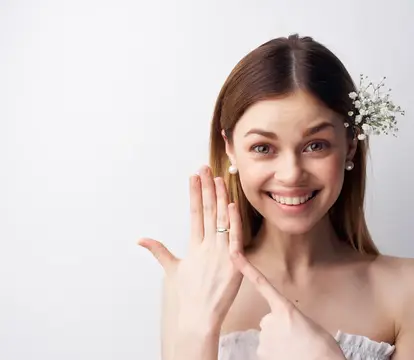 Улыбающаяся невеста показывает кольцо на руке