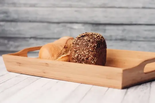 Белый и темный хлеб из цельного зерна, домашняя выпечка на деревянном подносе, завтрак