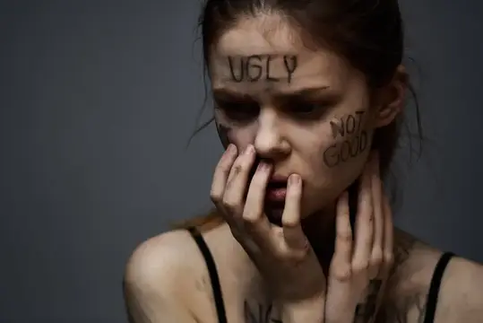 Молодая женщина с надписями Ugly и Not Good на лице