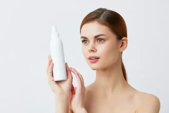 Молодая женщина с белым флаконом косметики в руках