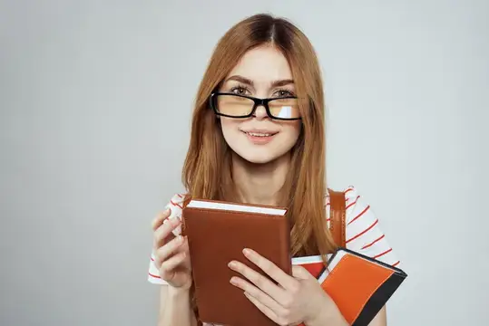 Умная девушка, студентка университета, с блокнотами и в очках