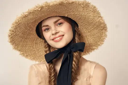 Улыбающаяся девушка в соломенной шляпе с чёрной лентой