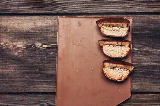 Три половинки сэндвича с курицей на коричневой доске