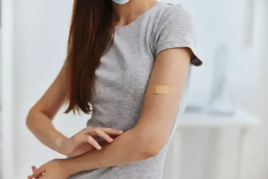 Пациент с пластырем на плече в больнице во время вакцинации