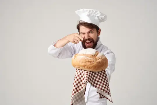Пекарь с хлебом в руке на изолированном фоне