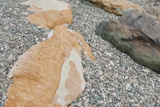 Крупные камни с песчаными разводами лежат на мелкой гальке