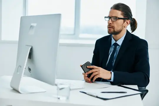 Офисный работник работает за компьютером с документами