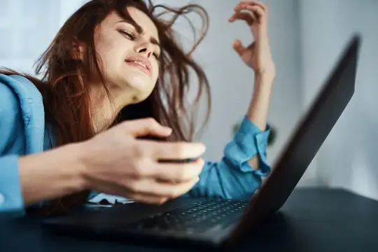 Недовольная женщина перед ноутбуком, расстроенная, уставшая от работы