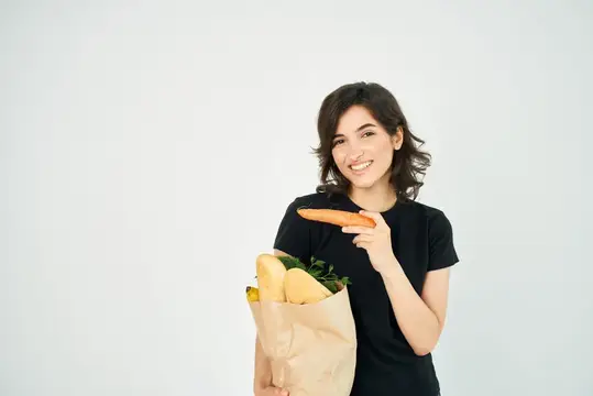 Весёлая брюнетка с пакетом продуктов, доставка здоровой еды, супермаркет