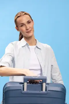 Молодая женщина с чемоданом на голубом фоне