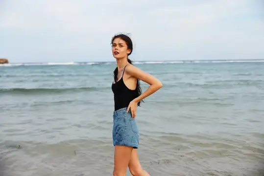 Женщина на пляже у моря на закате