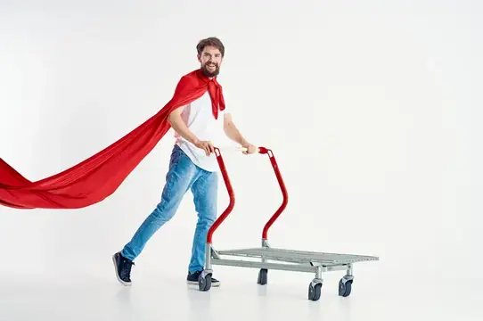 Улыбающийся бородатый мужчина в красной накидке везёт тележку