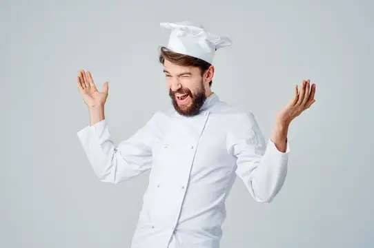 Повар-мужчина на кухне, жестикулирующий руками на светлом фоне