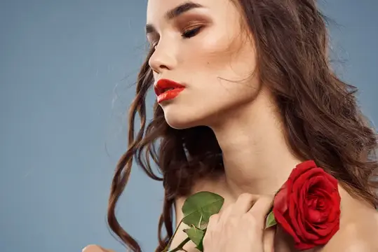 Молодая женщина с красной розой на голубом фоне
