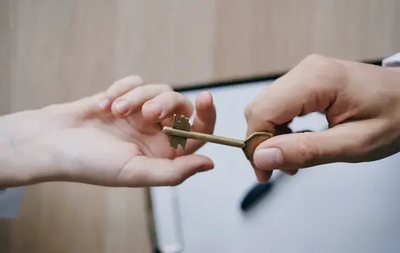 Передача ключа из рук в руки в офисе, связанная с бизнесом, финансами и работой с документами