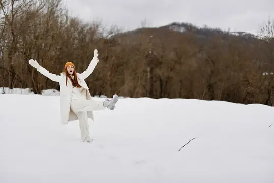 Счастливая молодая женщина гуляет по снегу, наслаждаясь весельем и природным пейзажем
