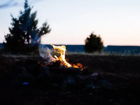 Яркий костёр горит на поляне в сумерках