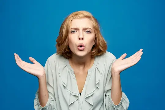 Симпатичная женщина жестикулирует руками, выражая эмоции на голубом фоне