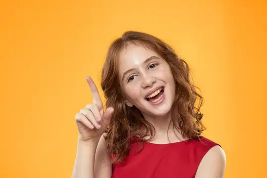 Девочка с кудрявыми волосами в красном платье