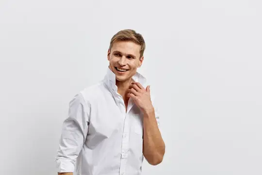 Счастливый улыбающийся мужчина в белой рубашке, повседневная мода, уверенное выражение лица, студийная обстановка, однородный фон, позитивное настроение, досуг, образ жизни, мужская модель
