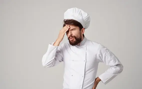 Мужчина-повар в колпаке, эмоции, профессиональная работа на кухне