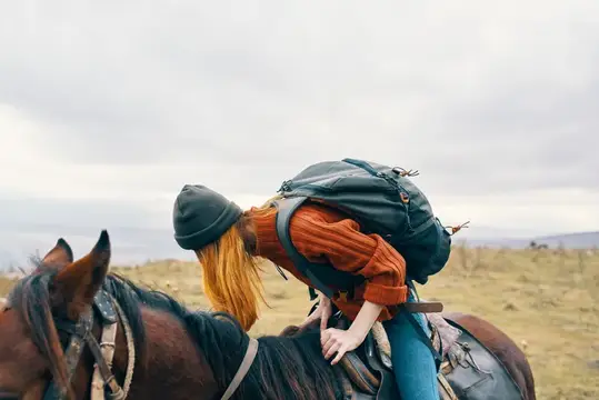 Женщина-туристка сидит верхом на лошади, наслаждаясь приключенческой поездкой на свежем воздухе