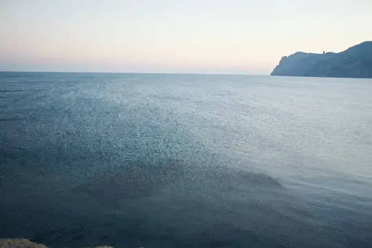 Спокойное море и скалистый берег на рассвете