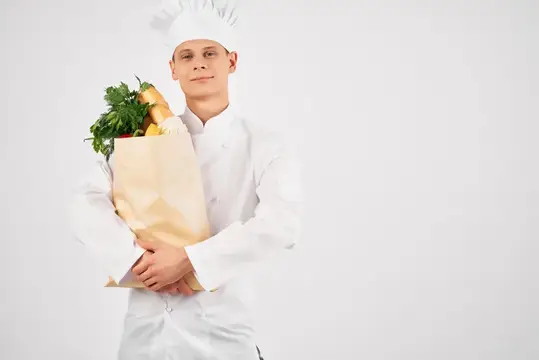 Мужчина в униформе повара с упаковкой продуктов жестикулирует рукой, здоровая еда на кухне