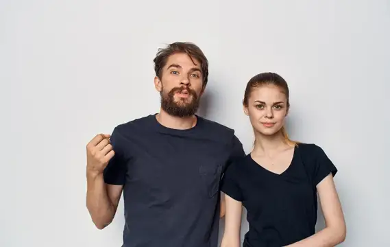 Молодая пара в чёрных футболках, весёлые эмоции, повседневная одежда, студийная съёмка